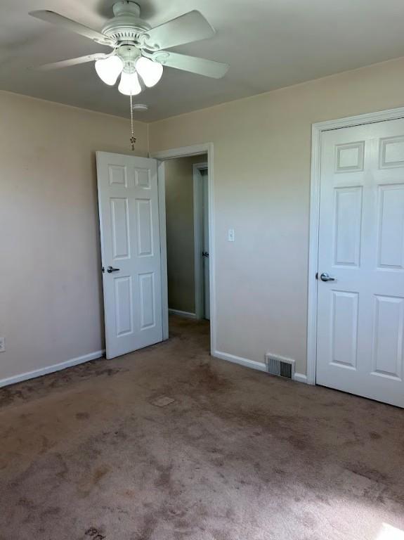 unfurnished bedroom with visible vents, carpet floors, and baseboards