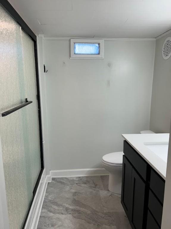full bath featuring toilet, a stall shower, vanity, and baseboards