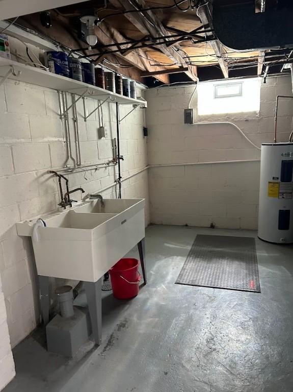 below grade area with electric water heater and a sink