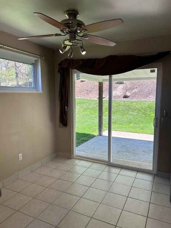 entryway with baseboards, light tile patterned floors, and a ceiling fan