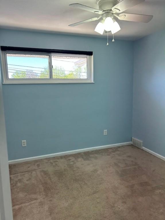 spare room with visible vents, ceiling fan, baseboards, and carpet floors