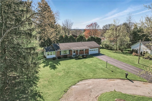 ranch-style house featuring brick siding, aphalt driveway, a front lawn, and an attached garage