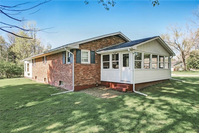 back of house featuring a lawn, entry steps, and brick siding