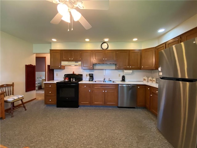 kitchen with stainless steel appliances, under cabinet range hood, carpet, light countertops, and a sink