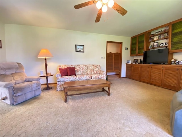 living area with a ceiling fan and light carpet