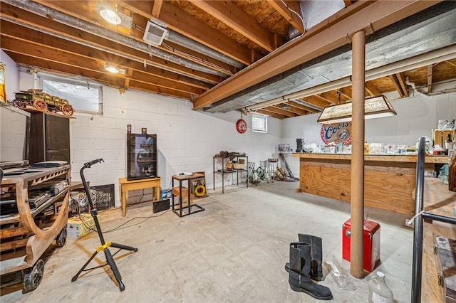 basement with a workshop area and concrete block wall