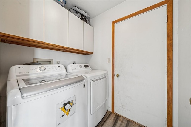 washroom with washer and dryer, cabinet space, and wood finished floors