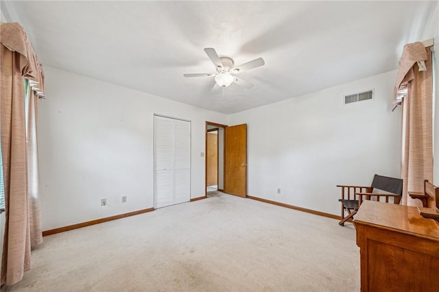 unfurnished bedroom featuring light colored carpet, visible vents, a closet, and baseboards
