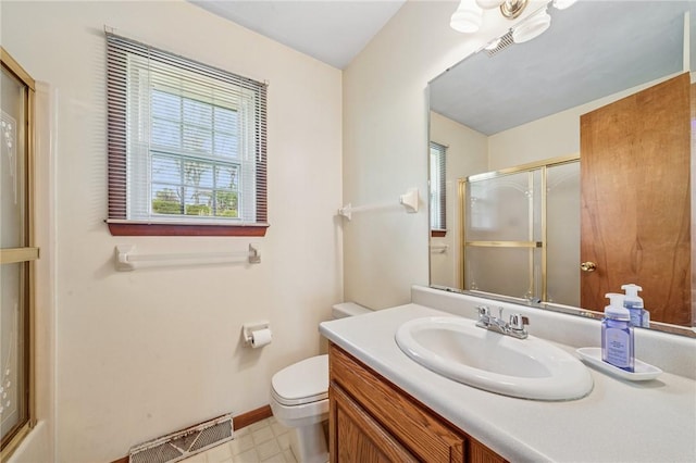 full bath featuring toilet, vanity, visible vents, and a shower with door