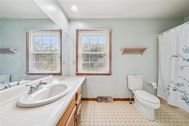 bathroom featuring tile patterned floors, vanity, toilet, and baseboards