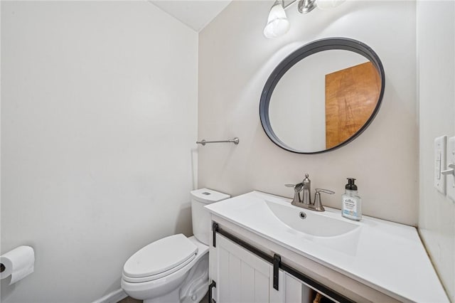 half bathroom with vanity and toilet