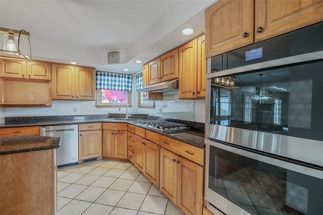 kitchen with light tile patterned floors, a sink, stainless steel appliances, under cabinet range hood, and recessed lighting