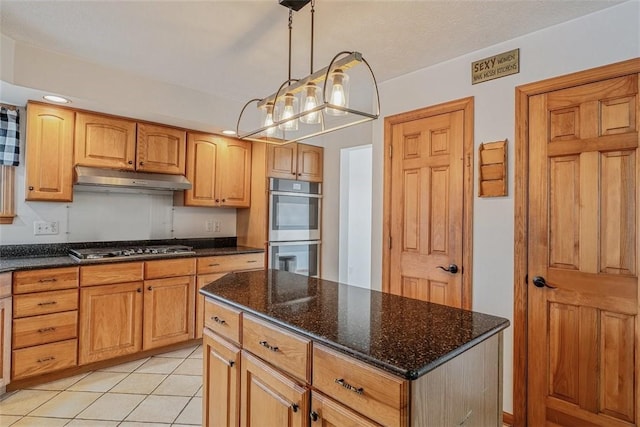 kitchen with dark stone countertops, pendant lighting, appliances with stainless steel finishes, under cabinet range hood, and recessed lighting