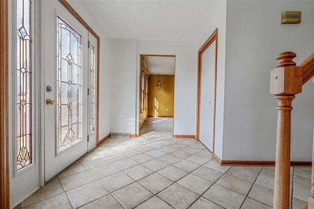 entrance foyer with baseboards, visible vents, and light tile patterned floors