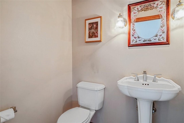 half bathroom with toilet and a sink