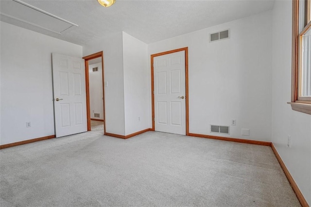 empty room with carpet flooring, visible vents, and baseboards
