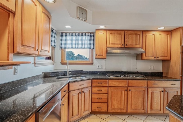 kitchen featuring dark stone counters, recessed lighting, a sink, stainless steel appliances, and under cabinet range hood