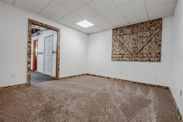 carpeted empty room with baseboards and a paneled ceiling