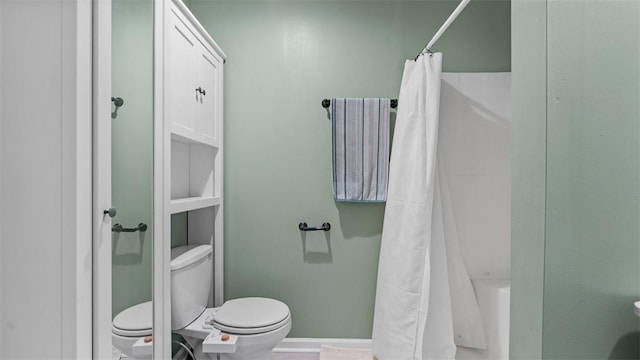 full bath featuring a tub to relax in, toilet, a shower with curtain, and baseboards