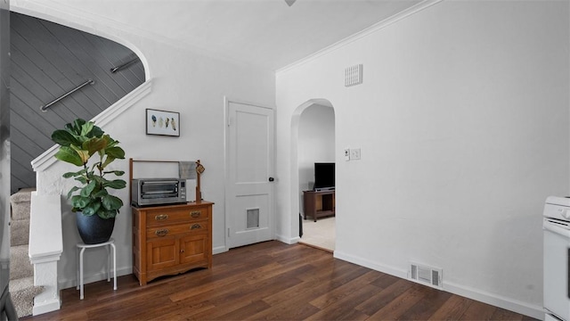 home office featuring dark wood-style flooring, visible vents, and arched walkways