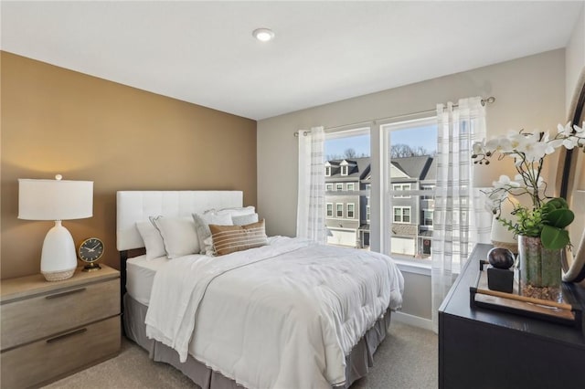 bedroom with multiple windows and light colored carpet