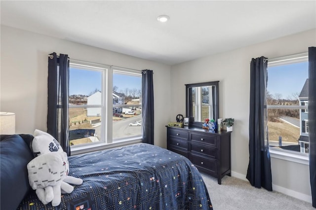 bedroom with baseboards and light carpet