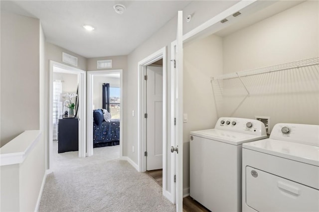 washroom with visible vents, carpet, washer and clothes dryer, and laundry area