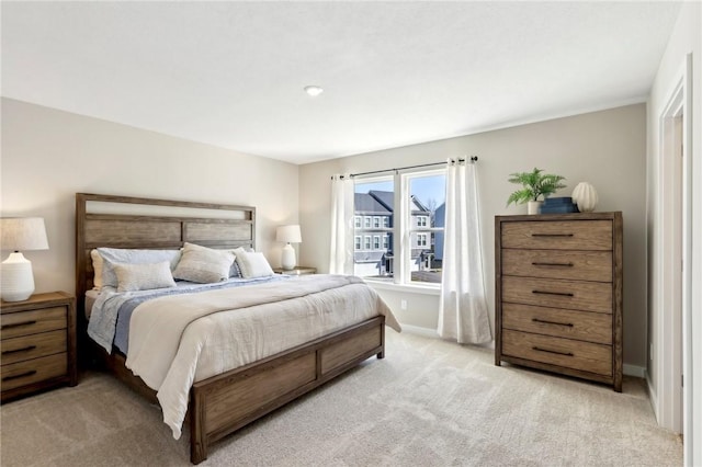 bedroom with baseboards and light carpet