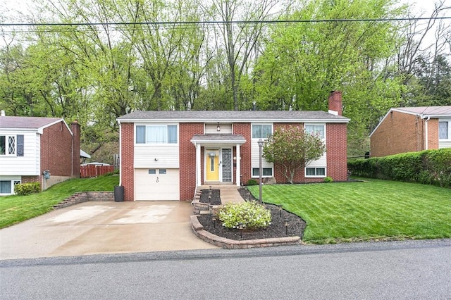 bi-level home with a chimney, concrete driveway, brick siding, and a garage