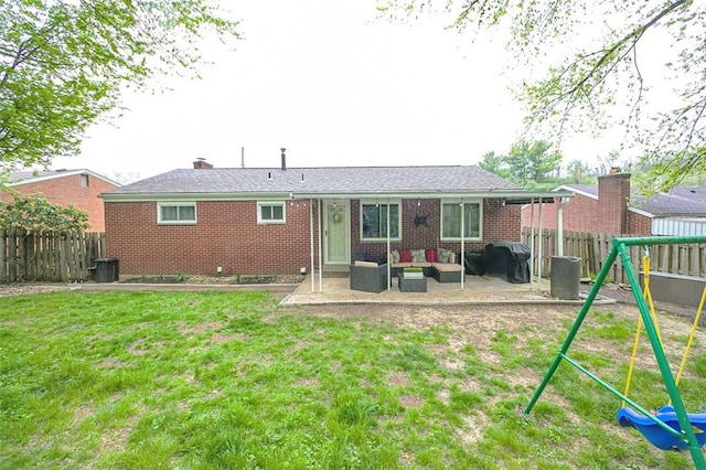 back of house featuring a patio, a playground, outdoor lounge area, a lawn, and a fenced backyard