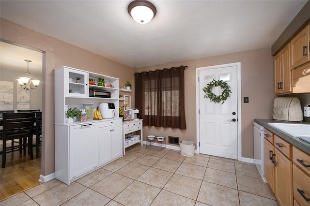 interior space featuring an inviting chandelier, light tile patterned floors, a sink, baseboards, and visible vents