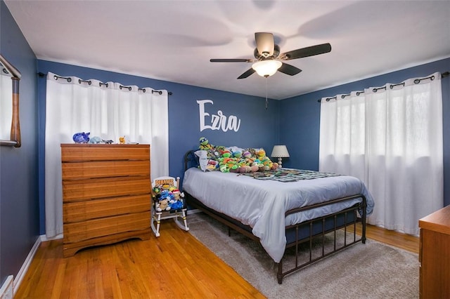 bedroom featuring ceiling fan, wood finished floors, and baseboards