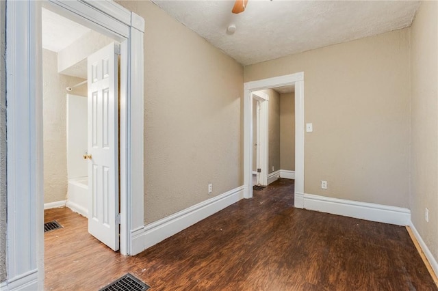 unfurnished room with wood finished floors, visible vents, and baseboards