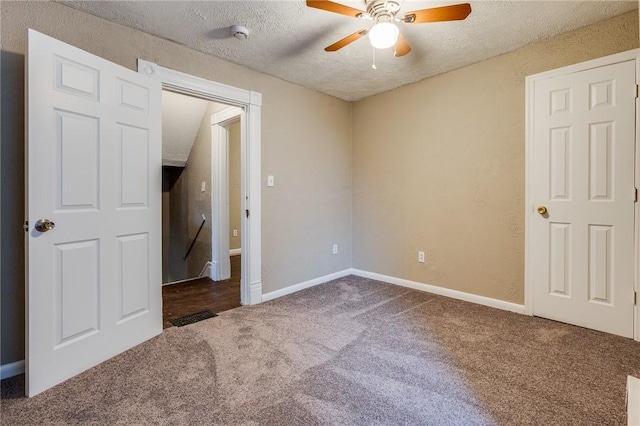 unfurnished bedroom with a textured ceiling, carpet flooring, ceiling fan, and baseboards