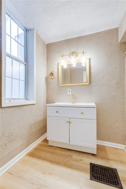 1226 Woodland Ave, Marshall Shadeland, PA 15212 - bathroom with baseboards, wood finished floors, a textured wall, and vanity