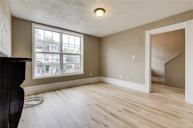 1226 Woodland Ave, Marshall Shadeland, PA 15212 - unfurnished living room with wood finished floors, plenty of natural light, a textured ceiling, baseboards, and a textured wall