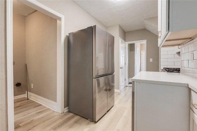 1226 Woodland Ave, Marshall Shadeland, PA 15212 - kitchen with freestanding refrigerator, light wood-type flooring, light countertops, baseboards, and a textured ceiling