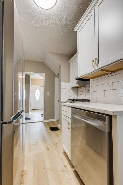 1226 Woodland Ave, Marshall Shadeland, PA 15212 - kitchen with appliances with stainless steel finishes, light wood-style floors, backsplash, light countertops, and a textured ceiling