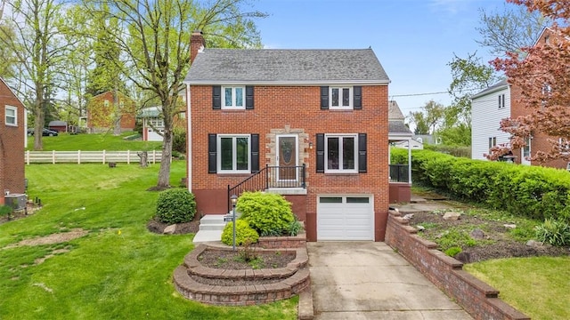 colonial home featuring a front yard, a garage, brick siding, driveway, and a chimney