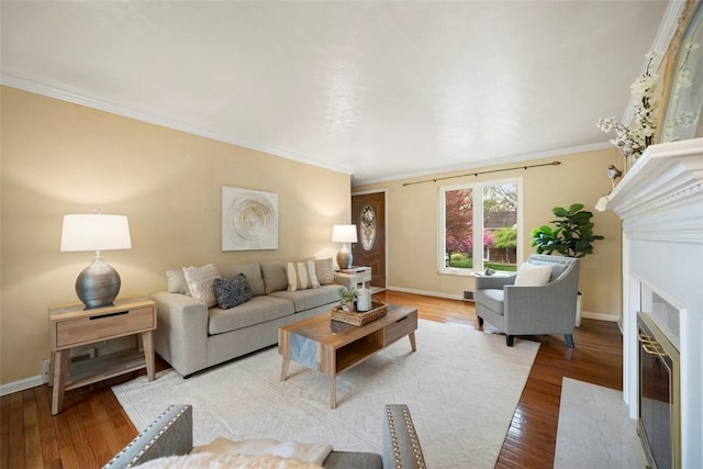 living area featuring baseboards, light wood finished floors, a fireplace with flush hearth, and crown molding