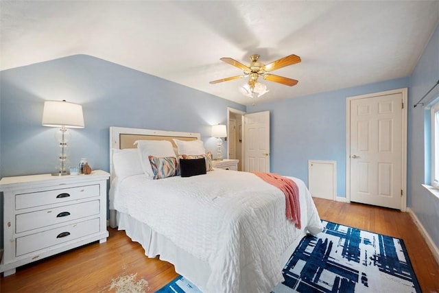 bedroom featuring baseboards, wood finished floors, and a ceiling fan