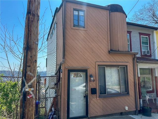 view of front of home featuring cooling unit, a gate, and fence