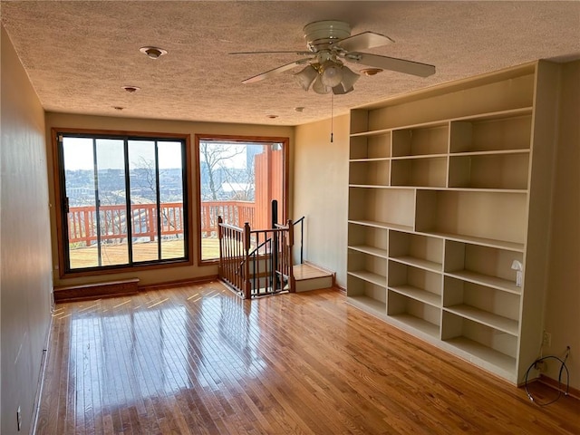 unfurnished room with a textured ceiling, plenty of natural light, and wood-type flooring