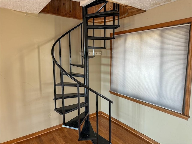 stairs featuring wood finished floors and baseboards