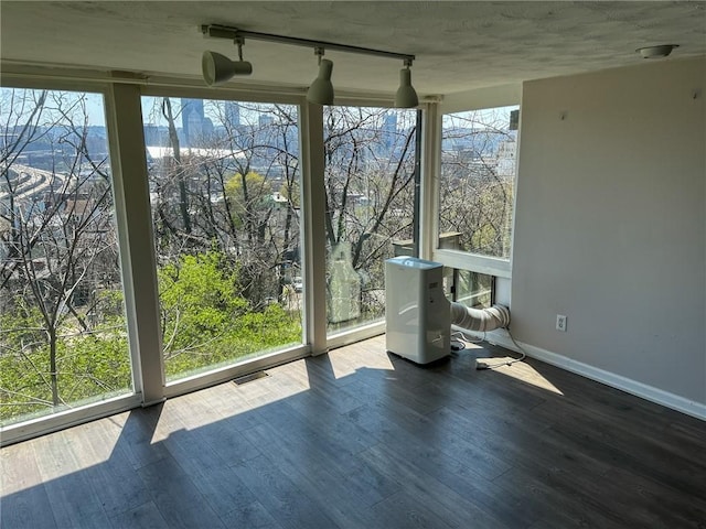 unfurnished sunroom with track lighting, a healthy amount of sunlight, and visible vents