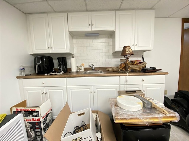 240 Hamburg Rd, Hempfield Twp Mer, PA 16125 - kitchen featuring a paneled ceiling, white cabinetry, decorative backsplash, and a sink