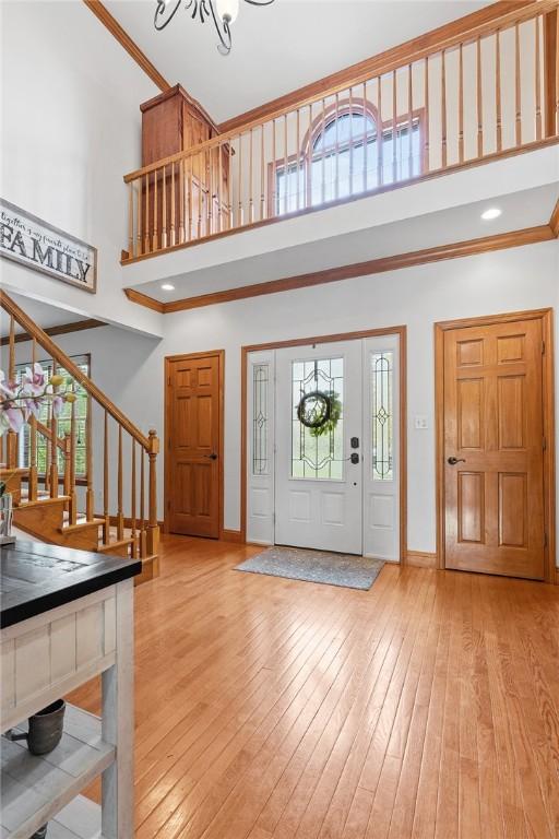302 Castanea Dr, Cranberry Twp, PA 16066 - foyer with stairs, a high ceiling, crown molding, and light wood-type flooring