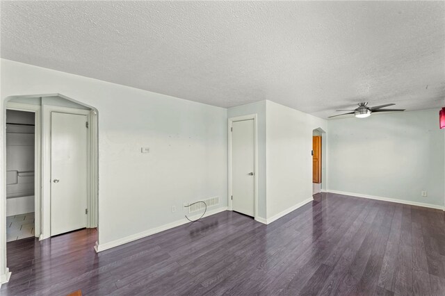 interior space featuring arched walkways, a ceiling fan, wood finished floors, and a textured ceiling