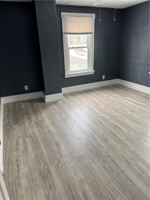 empty room featuring baseboards and wood finished floors
