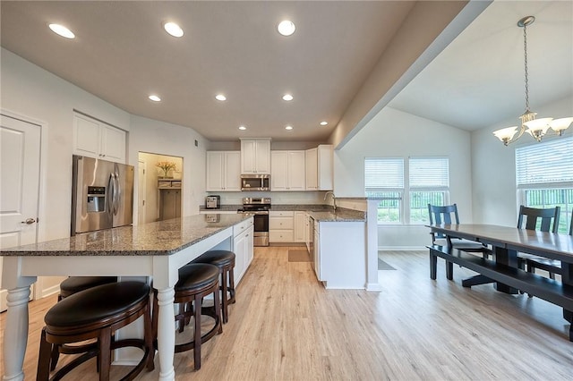 605 Saddle Ct, Moon/Crescent Twp, PA 15108 - kitchen with stainless steel appliances, light wood-style floors, a kitchen island, white cabinets, and a sink